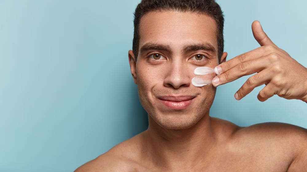 Man applying a cream to his face